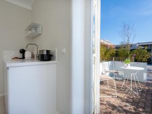 a kitchen with a view of a patio with a table at Duinsuite in Oostkapelle