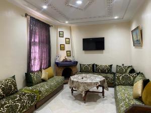 a living room with a couch and a table at Villa Sais avec piscine in Meknès
