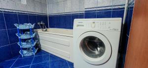 a blue tiled laundry room with a washing machine at Modest Ultra Central Apartment Council Square in Braşov