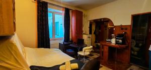 a bedroom with a bed and a desk and a window at Modest Ultra Central Apartment Council Square in Braşov