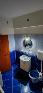a blue tiled bathroom with a toilet and a sink at Modest Ultra Central Apartment Council Square in Braşov