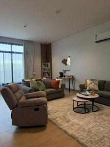 a living room with two couches and a table at شقة الدانة وصول ذاتي القيصومه in Hafr Al-Batin