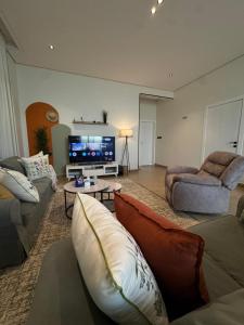 a living room with two couches and a tv at شقة الدانة وصول ذاتي القيصومه in Hafr Al-Batin +16 photos