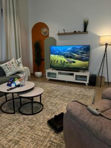 a living room with a couch and a flat screen tv at شقة الدانة وصول ذاتي القيصومه in Hafr Al-Batin