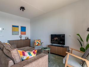 a living room with two couches and a flat screen tv at De Havenkamer in Kamperland +13 photos