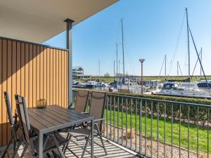 a wooden table and chairs on a balcony with a marina at De Havenkamer in Kamperland