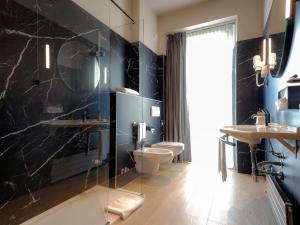 a bathroom with two toilets and a glass shower at Mercure Bergamo Centro Palazzo Dolci in Bergamo +94 photos