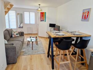 a living room with a table and a couch at Le Duplex Port & Plage in Dieppe +8 photos
