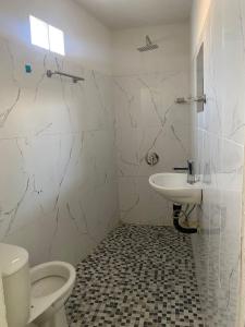 a white bathroom with a toilet and a sink at Casa alexander 3 in Acapulco