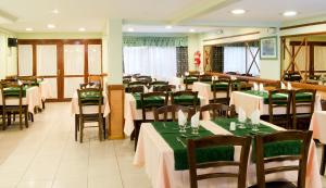 a restaurant with tables and chairs with green tablecloths at Hotel Internacional in San Carlos de Bariloche