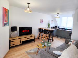 a living room with a couch and a kitchen at Le Duplex Port & Plage in Dieppe