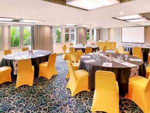a conference room with tables and yellow chairs at Mercure Kuta Bali in Kuta +216 photos