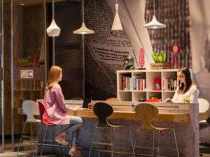 two women sitting at a table in a coffee shop at Ibis Warszawa Stare Miasto in Warsaw