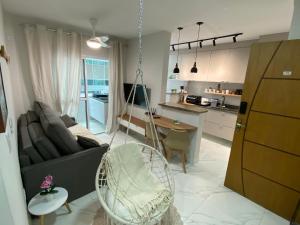 a living room with a couch and a swing at Atlântico 33 Guilhermina in Praia Grande