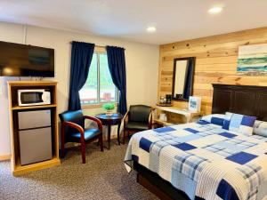 a hotel room with a bed and a table and chairs at Mountain View Lodge & Cabins in Hill City