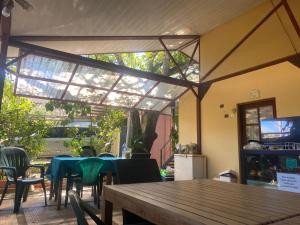 a patio with a table and chairs and a glass roof at Cabinas surf Arribadas in Ostional