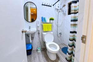 a bathroom with a toilet and a sink and a mirror at CLBC Residences 1A in Ibaba +25 photos