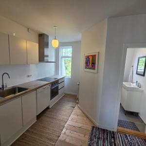 a kitchen with white cabinets and a sink at Bjerregade Horsens Centrum in Horsens