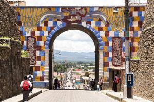 an archway in a city with people walking through it at Hotel casa de doña Rome in Chichicastenango