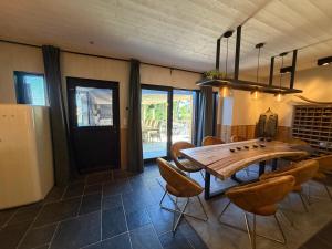 een eetkamer met een houten tafel en stoelen bij Saintbarth in Houyet