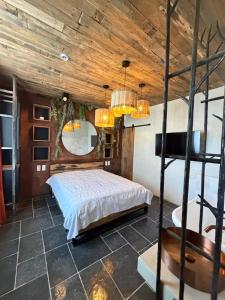een slaapkamer met een bed en een houten plafond bij Saintbarth in Houyet
