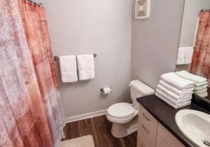 a bathroom with a toilet and a sink and a shower at Casa Marigold in Des Moines +16 photos