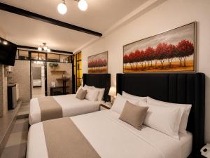 a bedroom with two beds and a painting on the wall at Ica Adventures II in Ica