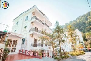 a large white building with trees in front of it at Nhà của Vân in Tam Ðảo