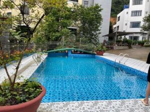 a large pool with blue water in a building at Nhà của Vân in Tam Ðảo