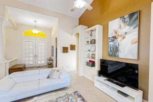 a living room with a white couch and a flat screen tv at Waterfront Hideaway in Cape Coral
