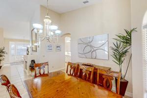 a living room with a dining room table and a chandelier at Waterfront Hideaway in Cape Coral