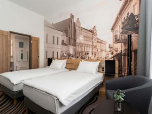 two beds in a room with a wall mural at Novotel Vilnius Centre in Vilnius
