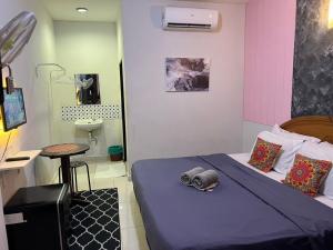 a room with a bed and a table in it at Little Chenang Cottage Motel Langkawi in Pantai Cenang