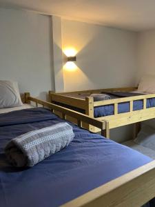 two bunk beds in a room with a blue bed at Little Chenang Cottage Motel Langkawi in Pantai Cenang