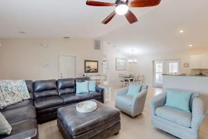 a living room with a couch and chairs and a ceiling fan at No Regrets in Englewood