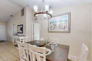 a dining room with a table and chairs and a chandelier at No Regrets in Englewood +20 photos