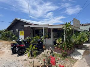 a group of motorcycles parked in front of a building at Little Chenang Cottage Motel Langkawi in Pantai Cenang