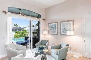 a living room with chairs and a glass table at Marco Island Majesty in Marco Island +33 photos