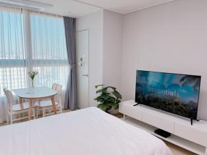 a white room with a bed and a table and a tv at Guri Residence in Guri +30 photos