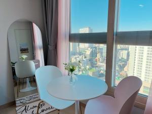 a white table and chairs in a room with a window at Guri Residence in Guri