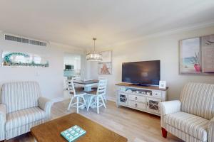 a living room with a television and a table with chairs at Marco Beach Ocean Resort 801 in Marco Island