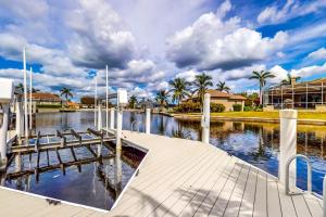 a dock with benches next to a body of water at Marco Island Manor in Marco Island