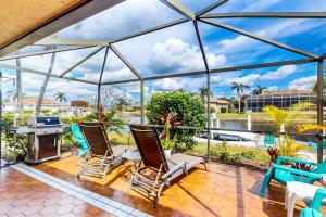 a conservatory with chairs and a view of the water at Marco Island Manor in Marco Island
