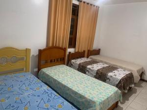 a bedroom with two beds and a window at Quartos petrolina 02 in Petrolina