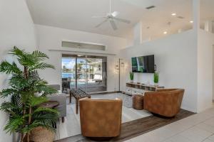 a living room with a couch and chairs and a tv at Hook, Line, and Sunsets in Port Charlotte