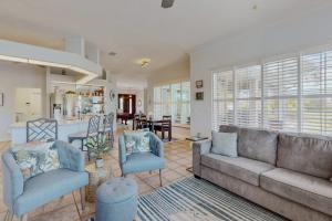 a living room with a couch and chairs and a kitchen at Endless Summer in Cape Coral +29 photos