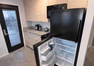 a black refrigerator with its door open in a kitchen at Cozy Greenwood Canopy in Des Moines