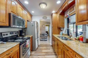 a kitchen with wooden cabinets and a stainless steel refrigerator at Cape Escape in Cape Coral