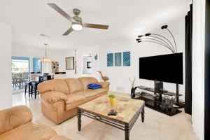 a living room with a couch and a flat screen tv at Three Palms Retreat in Cape Coral