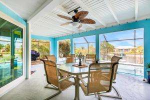 a dining room with a table and chairs and a ceiling fan at Three Palms Retreat in Cape Coral
